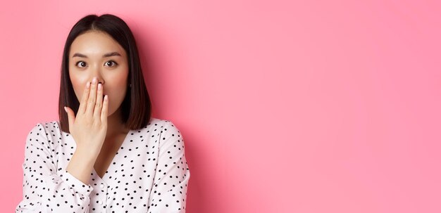 Retrato de una mujer joven de pie contra un fondo amarillo