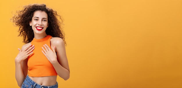 Foto retrato de una mujer joven de pie contra un fondo amarillo