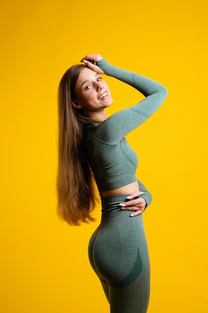 Retrato de una mujer joven de pie contra un fondo amarillo