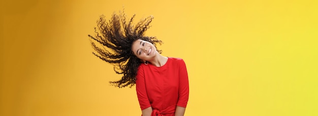 Foto retrato de una mujer joven de pie contra un fondo amarillo