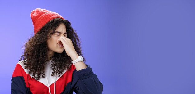 Retrato de una mujer joven de pie contra un fondo azul