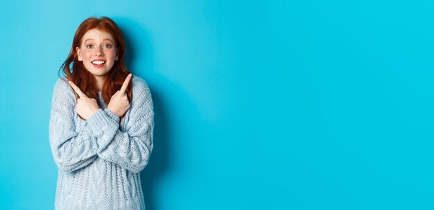 Retrato de una mujer joven de pie contra un fondo azul