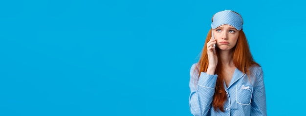 Retrato de una mujer joven de pie contra un fondo azul