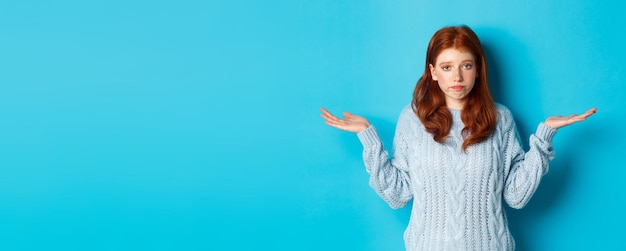 Retrato de una mujer joven de pie contra un fondo azul