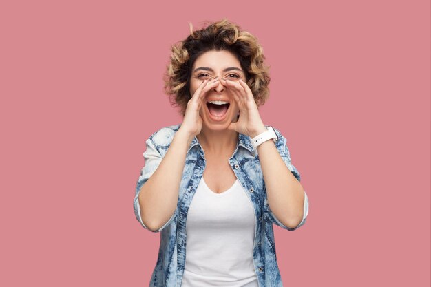 Foto retrato de una mujer joven de pie contra un fondo azul