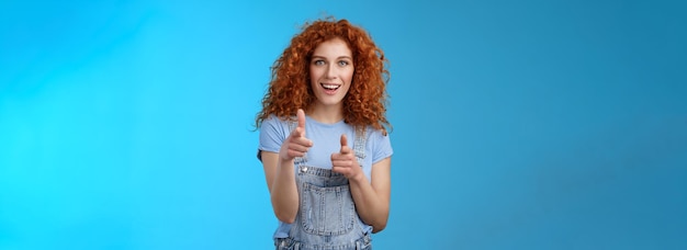 Retrato de una mujer joven de pie contra un fondo azul