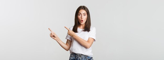 Foto retrato de una mujer joven de pie contra un fondo blanco