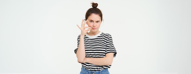 Foto retrato de una mujer joven de pie contra un fondo blanco