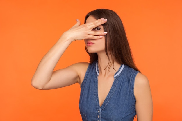 Foto retrato de una mujer joven de pie contra un fondo naranja