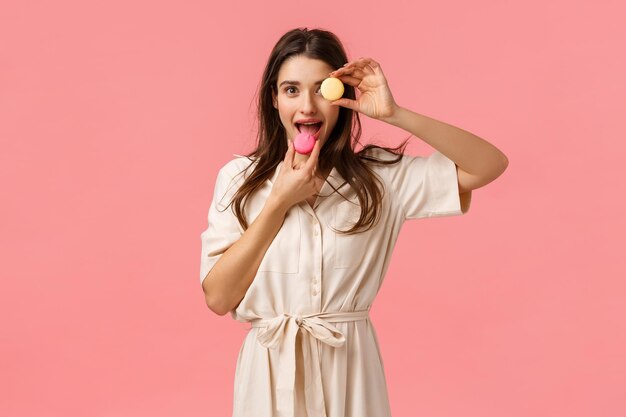 Foto retrato de una mujer joven de pie contra un fondo rosa