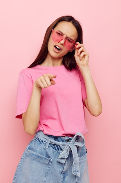 Foto retrato de una mujer joven de pie contra un fondo rosa