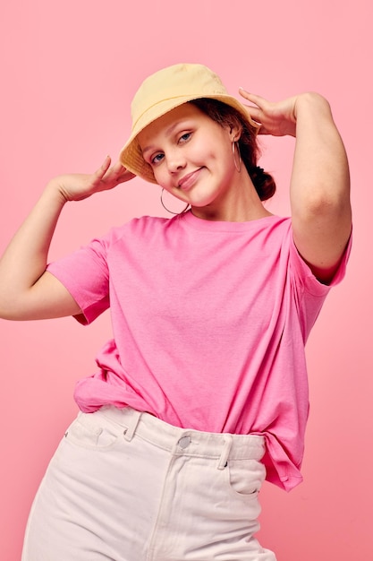 Foto retrato de una mujer joven de pie contra un fondo rosa