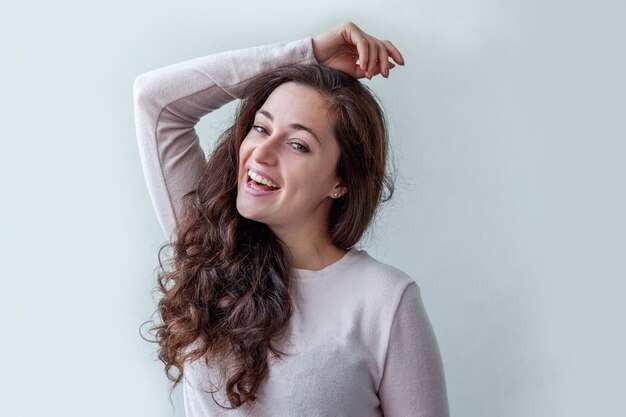 Foto retrato de una mujer joven de pie contra la pared