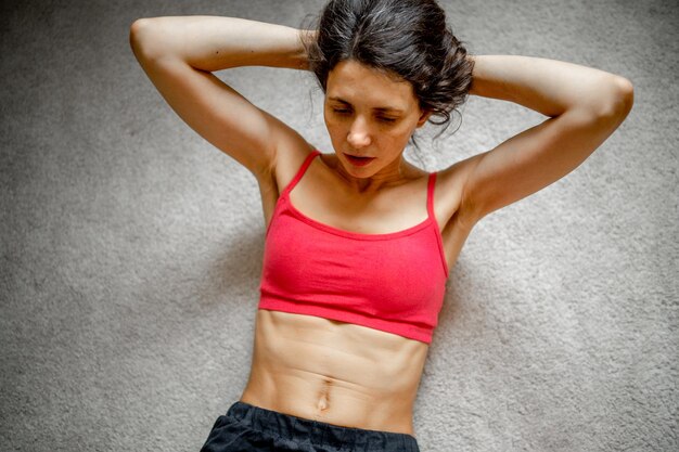 Foto retrato de una mujer joven de pie contra la pared