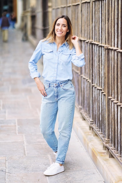 Retrato de una mujer joven de pie contra la pared