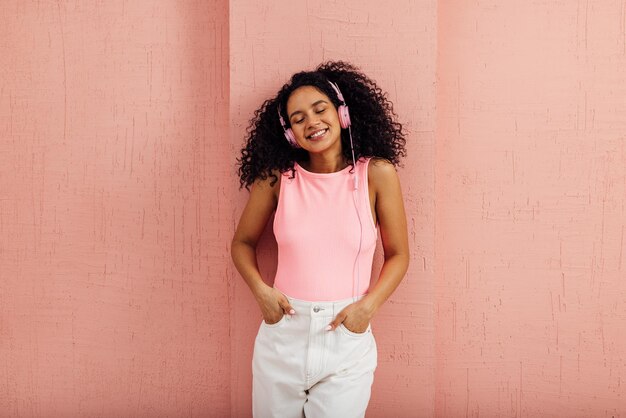 Foto retrato de una mujer joven de pie contra la pared