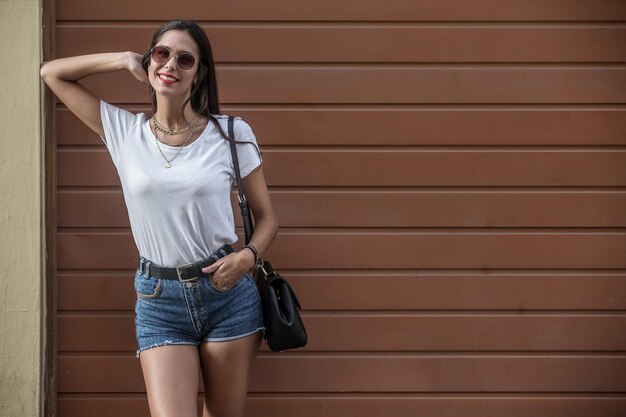 Foto retrato de una mujer joven de pie contra la pared