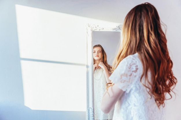 Foto retrato de una mujer joven de pie contra la pared