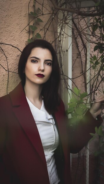 Foto retrato de una mujer joven de pie contra las plantas