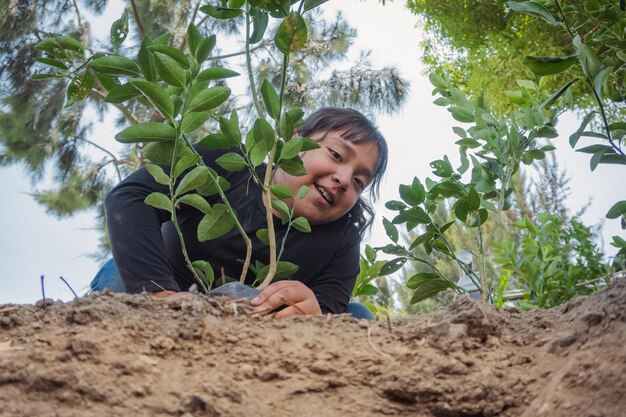 Retrato de una mujer joven de pie contra las plantas