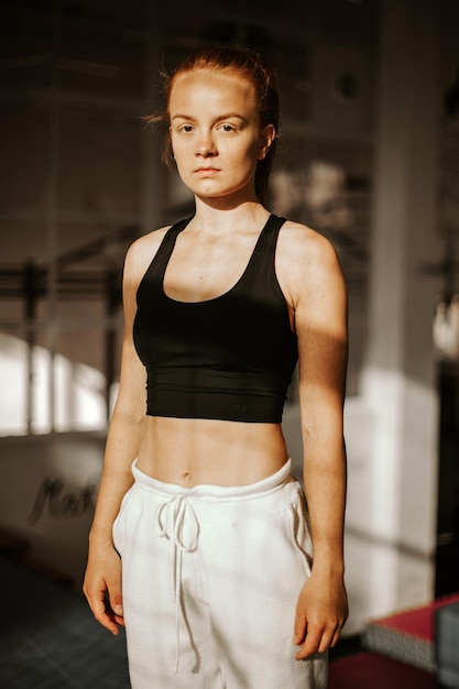 Retrato de una mujer joven de pie en el gimnasio