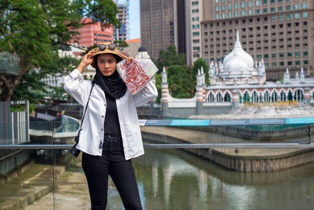 Foto retrato de una mujer joven de pie junto a un canal en la ciudad