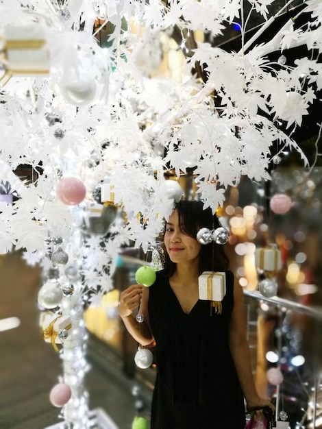 Foto retrato de una mujer joven de pie junto a la decoración