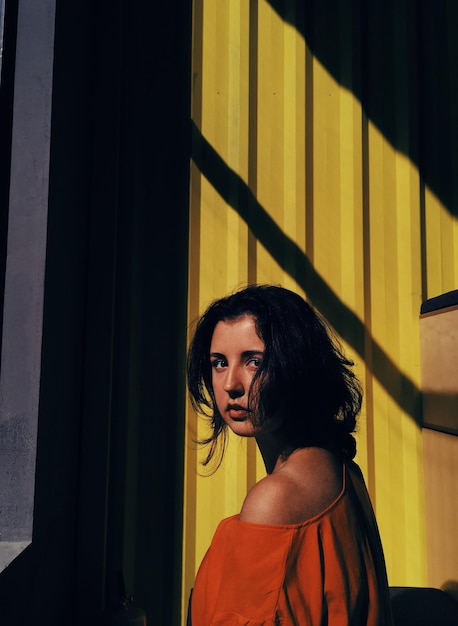 Retrato de una mujer joven de pie junto a la pared