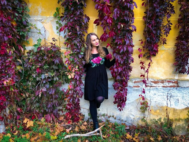 Foto retrato de una mujer joven de pie junto a las plantas