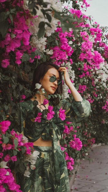 Foto retrato de una mujer joven de pie en medio de las plantas