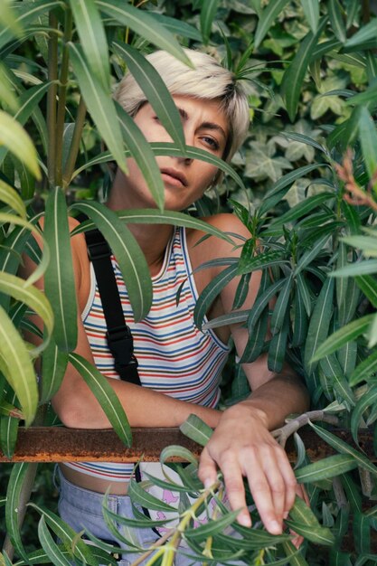 Foto retrato de una mujer joven de pie en medio de las plantas