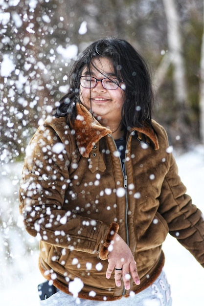 Foto retrato de una mujer joven de pie en la nieve