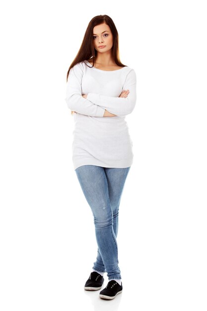 Foto retrato de una mujer joven de pie sobre un fondo blanco