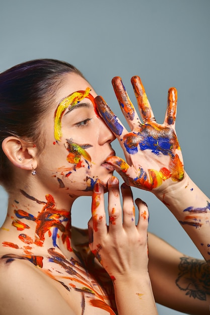 Retrato de una mujer joven pintada con diferentes colores.