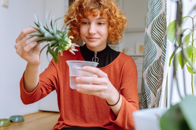 Foto retrato de una mujer joven con plántulas de piña decorativas