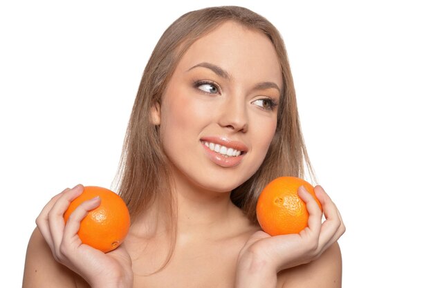 Retrato de mujer joven posando con naranjas aisladas sobre fondo blanco