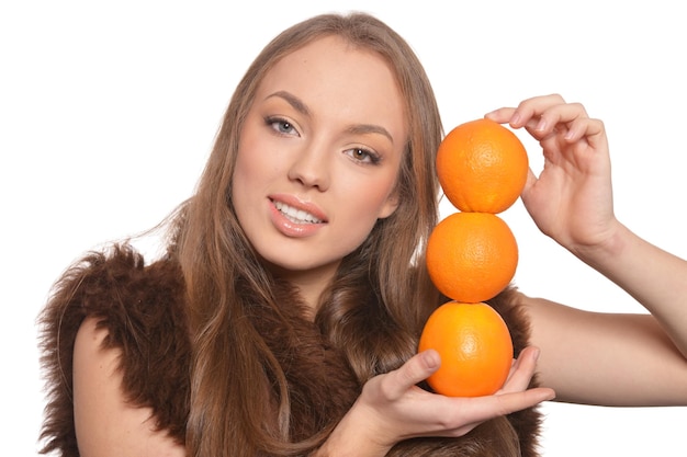 Retrato de mujer joven posando con naranjas aislado sobre fondo blanco.