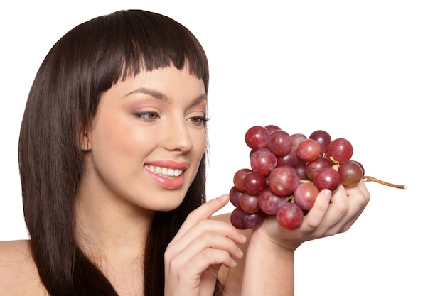 Retrato de mujer joven posando con uvas aislado sobre fondo blanco.