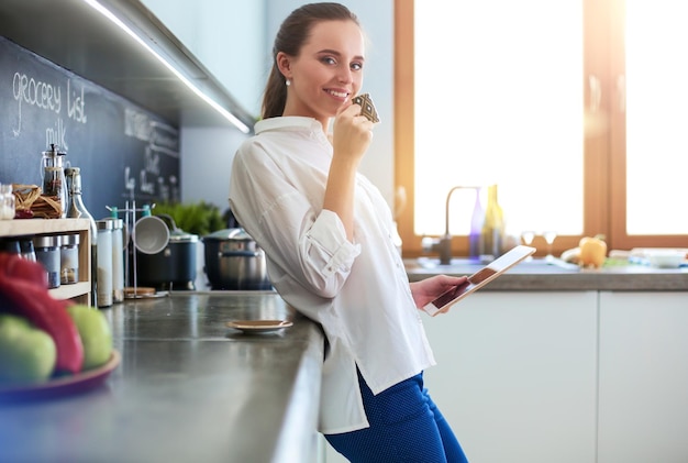 retrato, de, mujer joven, posición, contra, cocina, plano de fondo