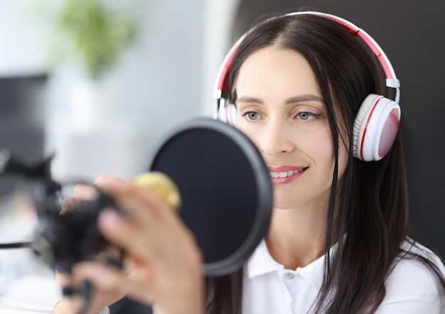 Retrato de mujer joven presentador de radio anuncia noticias en el lugar de trabajo