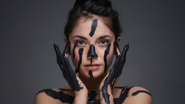 Foto retrato de una mujer joven que posa cubierta con pintura negra
