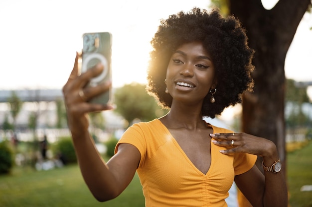 Retrato de una mujer joven que toma un selfie al aire libre