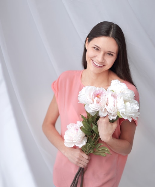 Retrato de una mujer joven con un ramo de peonías