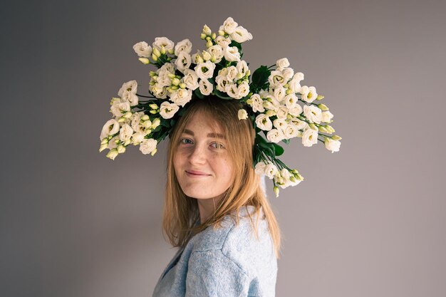 Retrato de una mujer joven con un ramo de rosas sobre un fondo gris