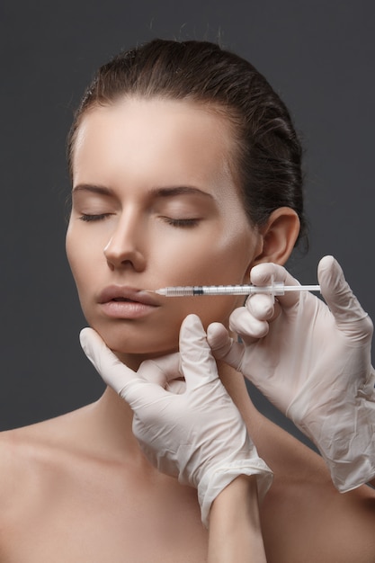 Retrato de mujer joven recibiendo inyección cosmética