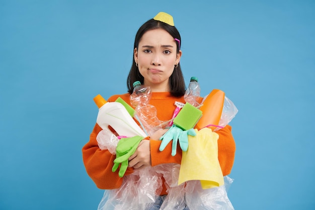 Retrato de una mujer joven con un regalo contra un fondo azul