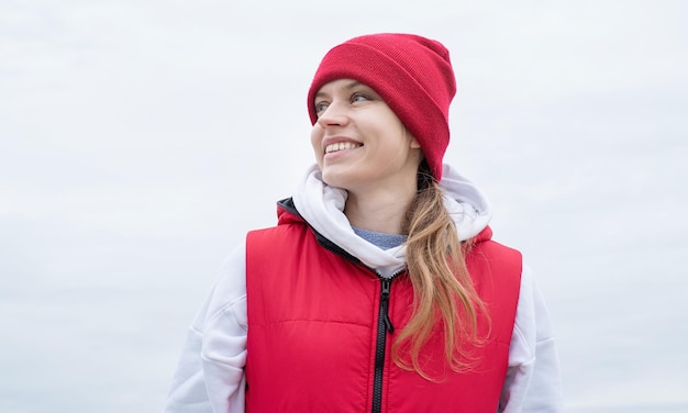 Retrato de mujer joven en ropa deportiva de color rojo y blanco brillante al aire libre