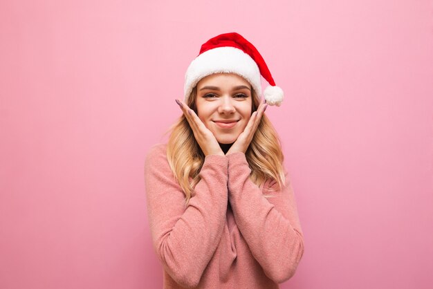 retrato, mujer joven, con, rosa, suéter, y, gorro de santa