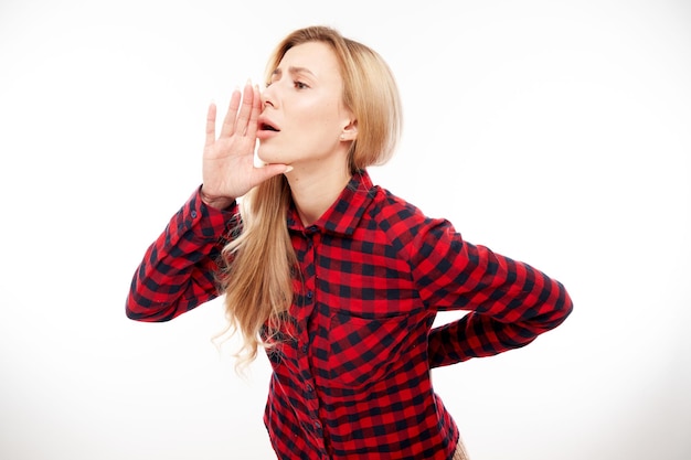 Foto retrato de mujer joven rubia gritando en sus palmas sobre fondo blanco de estudio información importante noticias conceptxa