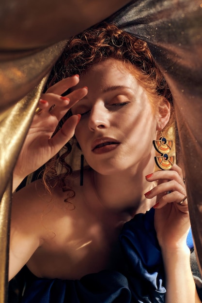 Retrato de una mujer joven bajo una sábana de oro